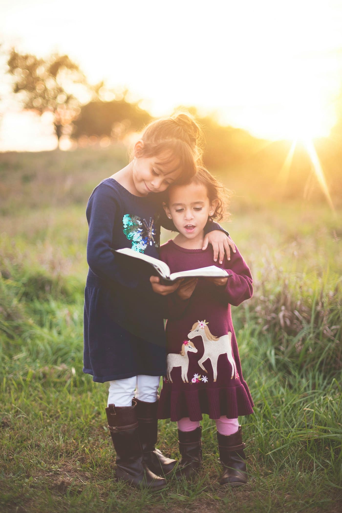 Two children reading together in golden evening light